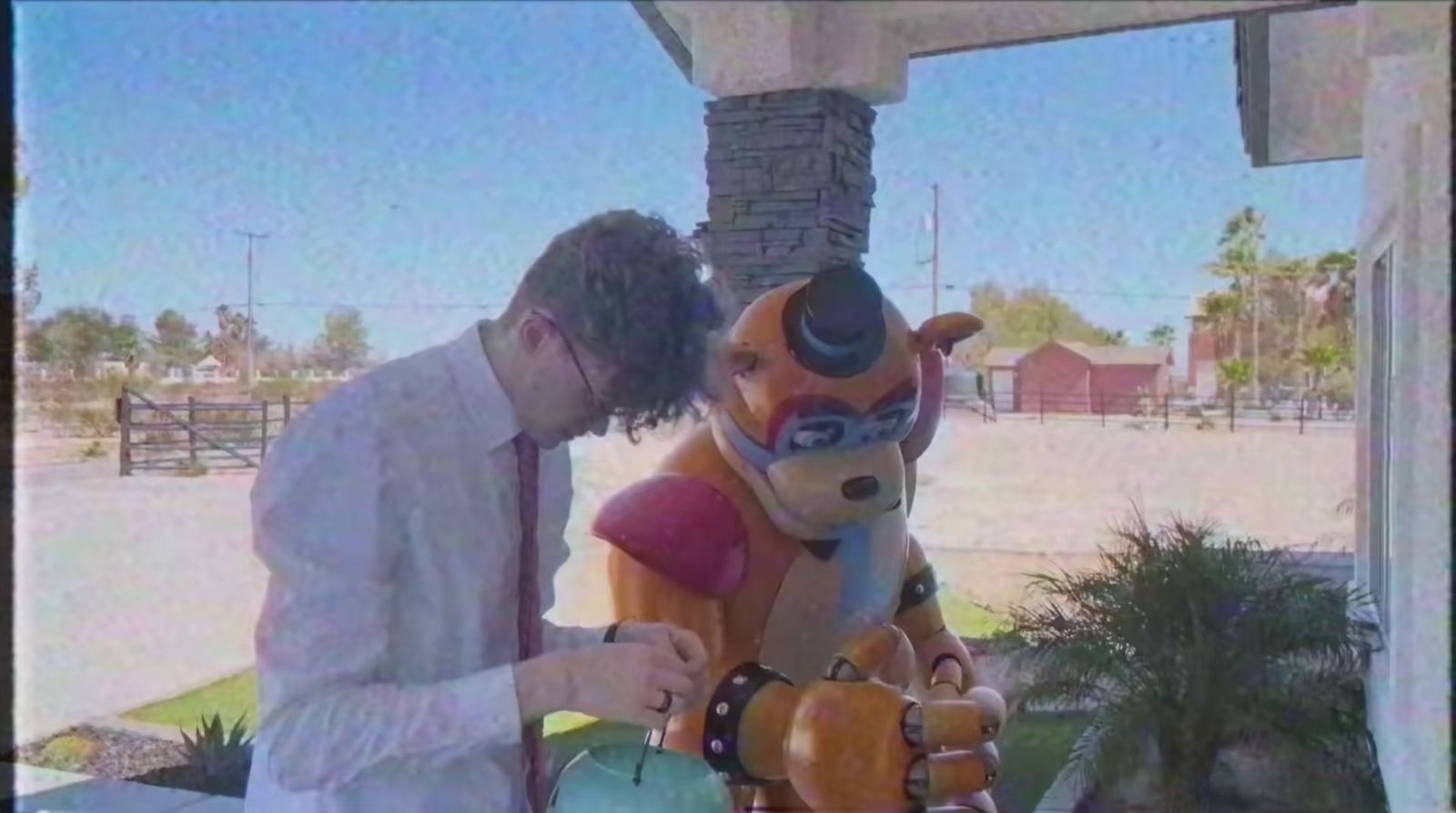 a man standing next to a giant teddy bear