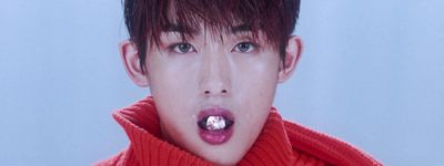 a man with a red sweater and a toothbrush in his mouth