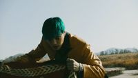 a man with green hair and a yellow jacket