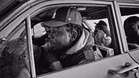 a black and white photo of a man in a car