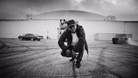 a man riding a skateboard across a parking lot