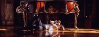 a woman laying on the floor in front of a table