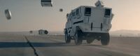 a military vehicle driving down a desert road