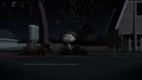 a little girl standing on the side of a road at night