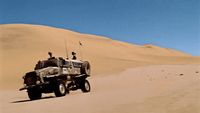 a military vehicle driving through the desert