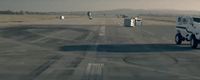 a large white truck driving down a runway