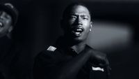 a black and white photo of a man singing into a microphone