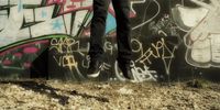 a person standing in front of a wall covered in graffiti