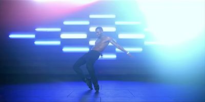 a shirtless man is dancing on a stage