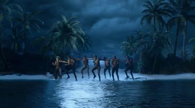 a group of people standing on top of a body of water