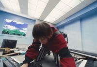 a man sitting in front of a keyboard in a room