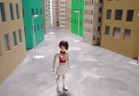 a little girl standing in a hallway between two buildings