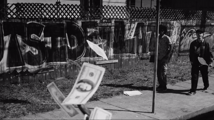 a black and white photo of a man standing on a sidewalk