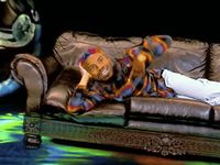 a man laying on top of a leather couch