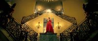 a woman in a red dress standing on a staircase