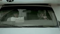 two women sitting in the back seat of a car