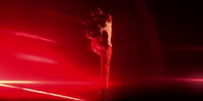 a man standing on top of a pole in the dark