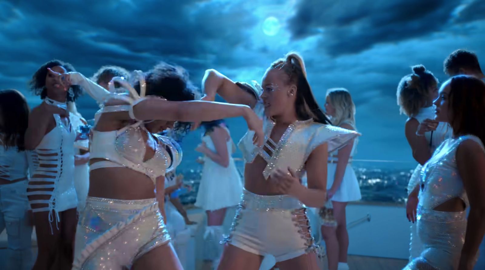 a group of women dancing on top of a roof