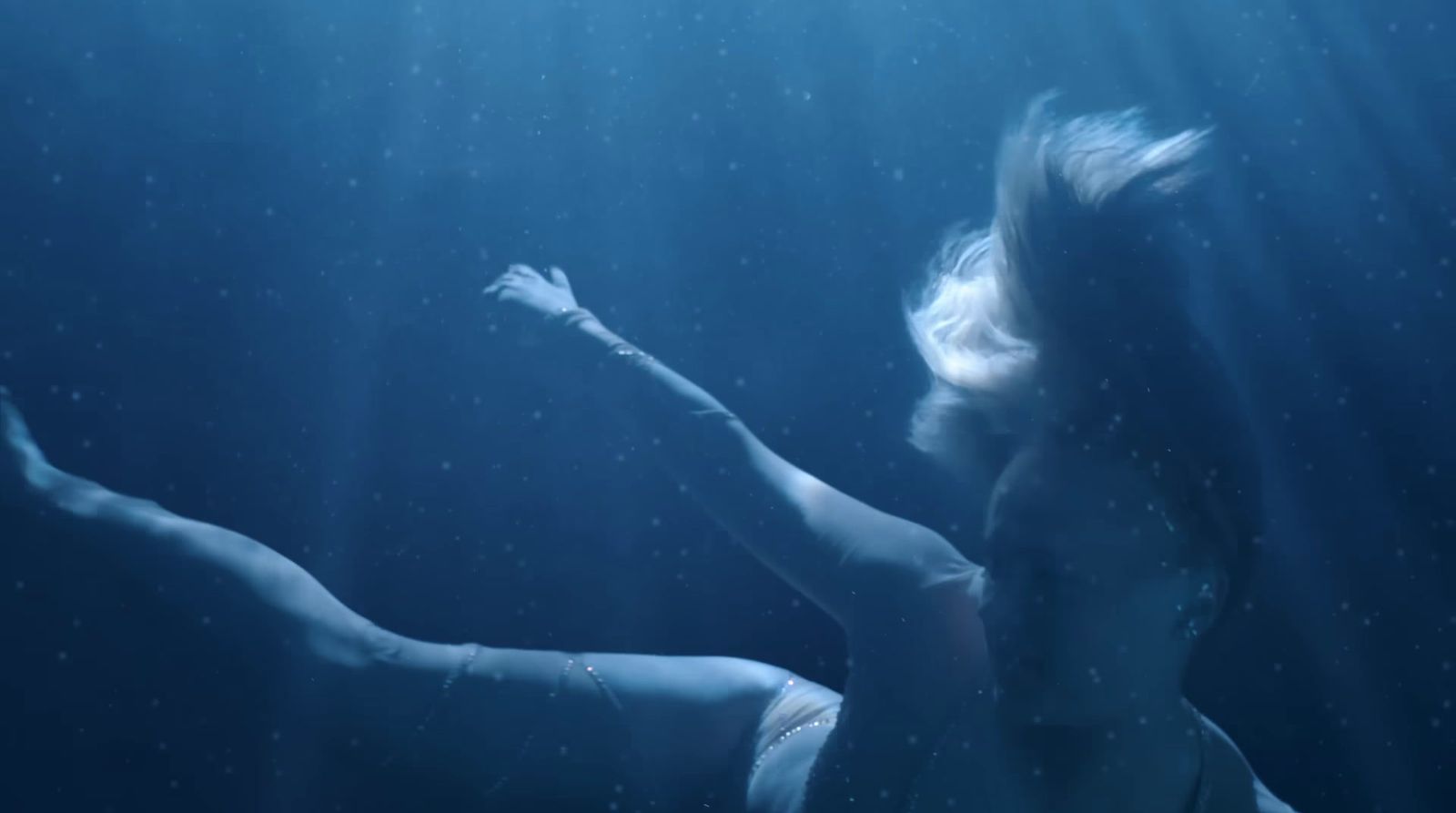 a woman floating in the water with her arms outstretched