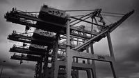 a large crane sitting on top of a building under a cloudy sky