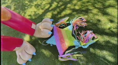 a group of hands holding a kite on top of a lush green field