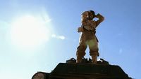 a statue of a man standing on top of a clock tower