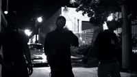 a group of men walking down a street at night