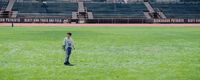 a person standing in a field with a baseball bat