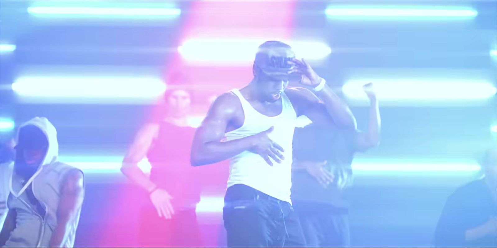 a man in a white tank top standing on stage