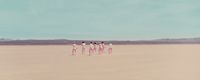 a group of people standing in the middle of a desert