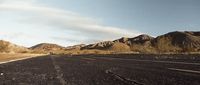 an empty road with mountains in the background