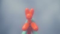 a red teddy bear sitting on top of a green object