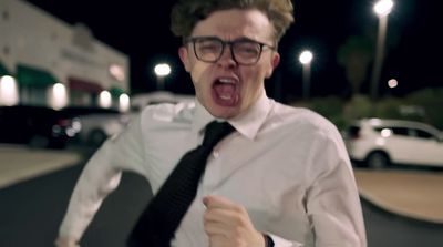 a man wearing glasses and a tie making a funny face