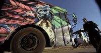 a man standing in front of a colorful bus