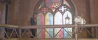 a man standing in front of a stained glass window