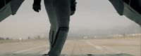 a person standing on a runway with their feet in the air