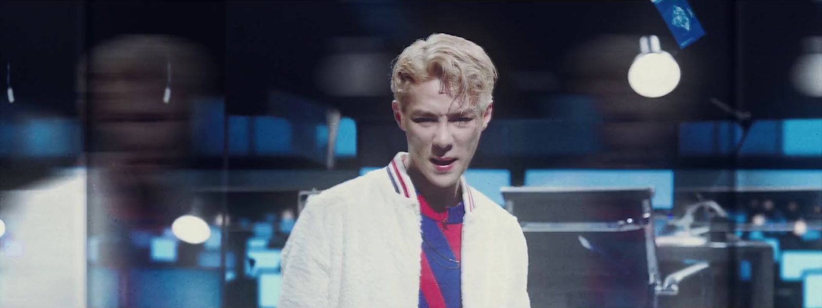 a man in a white jacket and a red and blue shirt