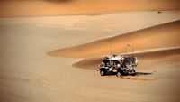 a truck driving through the desert in the sand