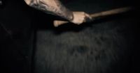 a man with a tattoo on his arm holding a baseball bat