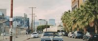 a street filled with lots of traffic next to tall buildings