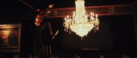 a woman standing in front of a chandelier