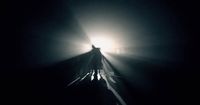 a person standing on a train track in the dark