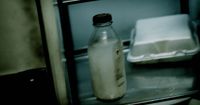 a bottle of milk sitting on top of a metal shelf