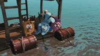 a group of stuffed animals sitting on top of a wooden dock