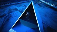 a man standing inside of a blue boat on top of a body of water