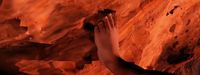 a person reaching up into the air on a rock