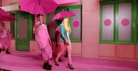 a group of people with pink umbrellas in a room