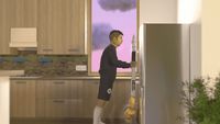 a man standing in a kitchen holding a large object