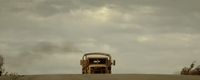 a tractor is driving down a dirt road