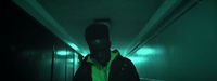 a person in a dark hallway with a neon green light